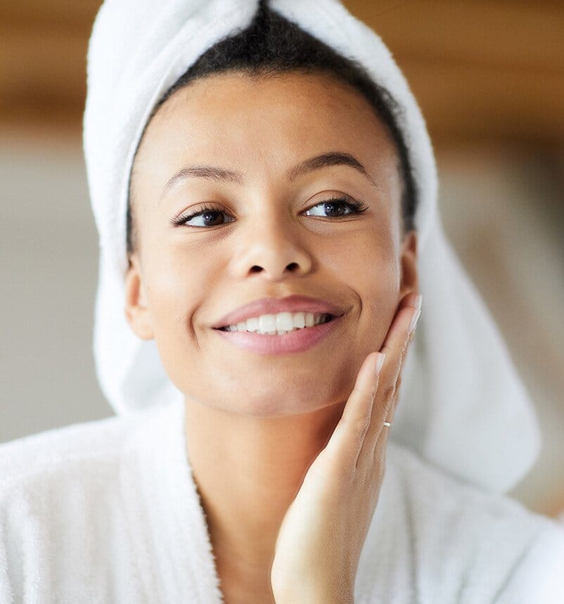 smiling woman in a towel wrapped around her head