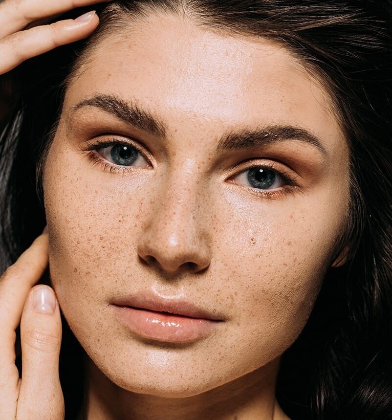 there is a woman with freckles on her face and a necklace