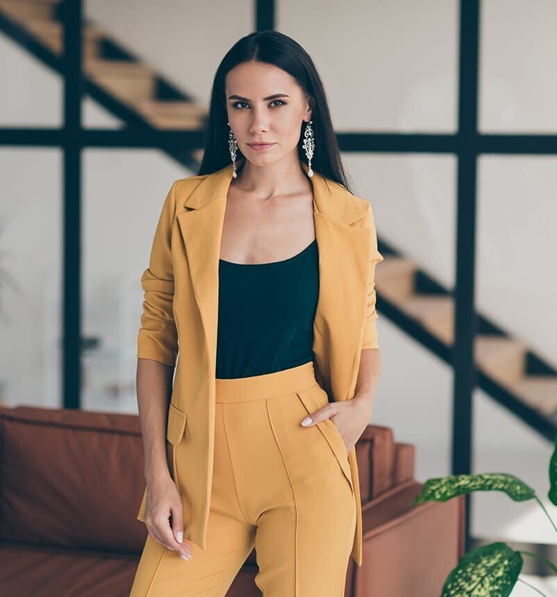 a woman in a yellow suit standing in a living room