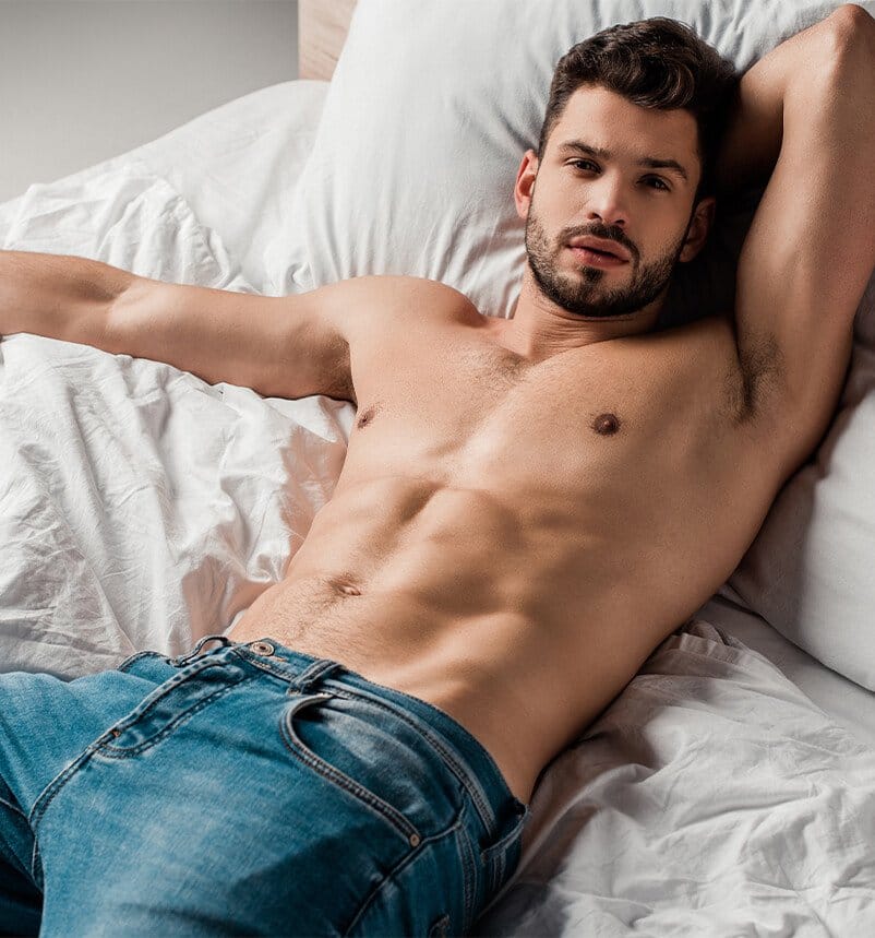 man laying in bed with his arms behind his head