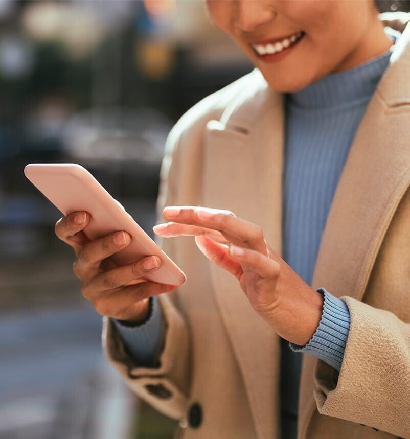 woman in a coat looking at her cell phone