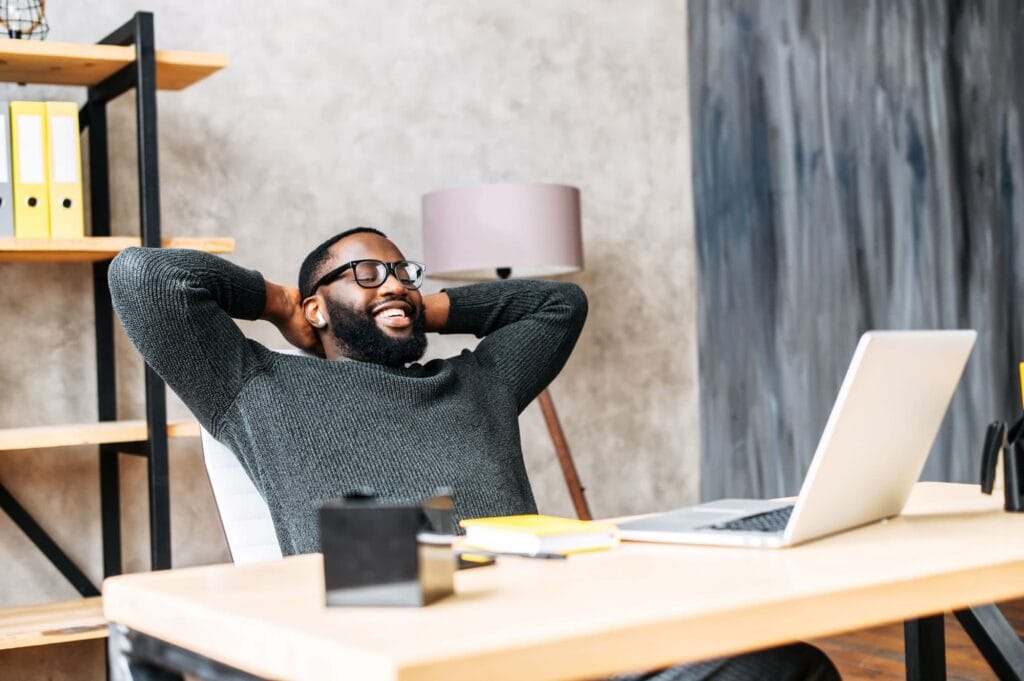 Man relaxed, leaning back at desk